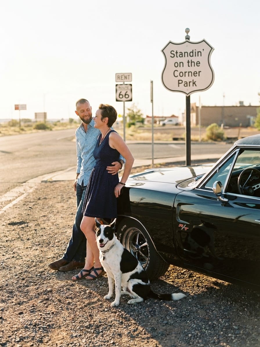 Michael and Tamara Kaeen with PATCHY beside their black 1969 Dodge Charger at Standin' on the Corner Park in Winslow, Arizona.